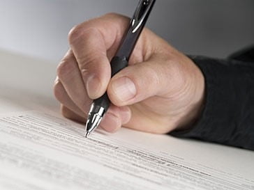 A man writing down his notes to complete his online tax return.